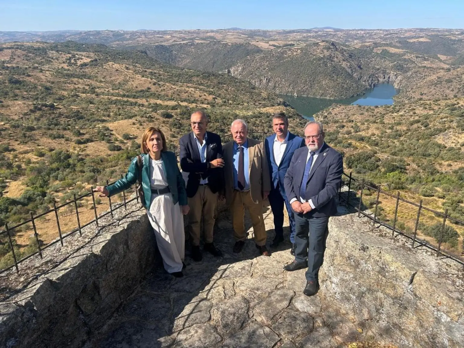 Grupo de personas en un mirador con paisaje montañoso al fondo