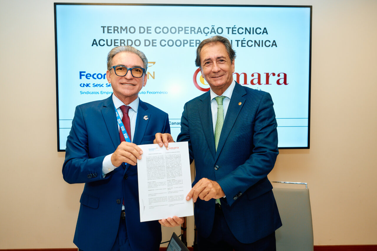 Dos hombres sosteniendo un acuerdo de cooperación en una ceremonia