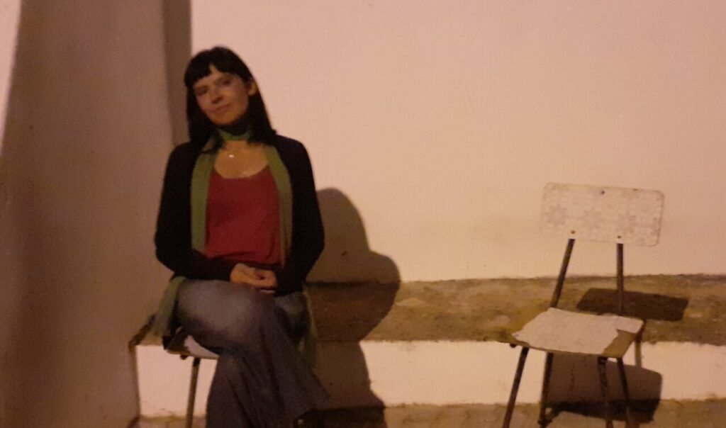 Mujer sentada en una silla frente a una pared blanca