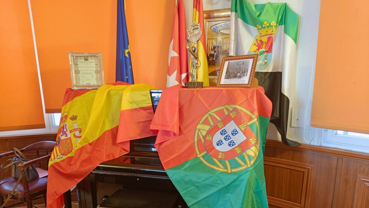 Mesa decorada con banderas de España y Portugal en un evento cultural