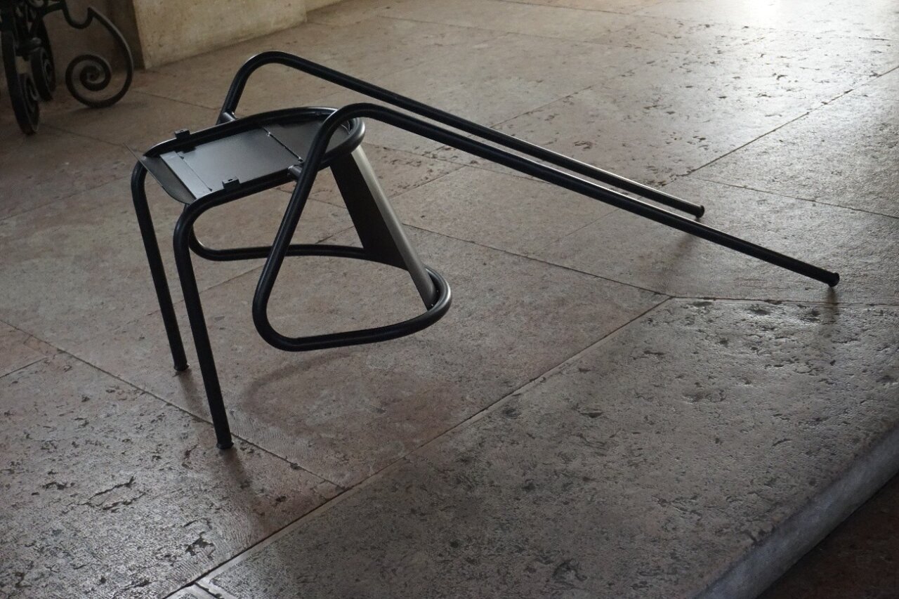 Escultura de una silla desarmada en una exposición de arte contemporáneo.