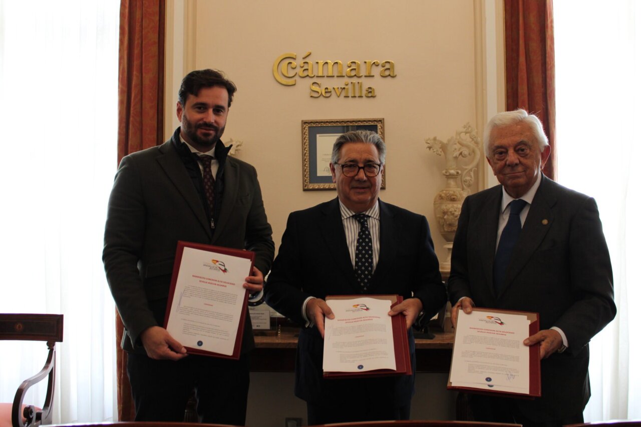 Tres hombres sosteniendo documentos en la Cámara de Comercio de Sevilla