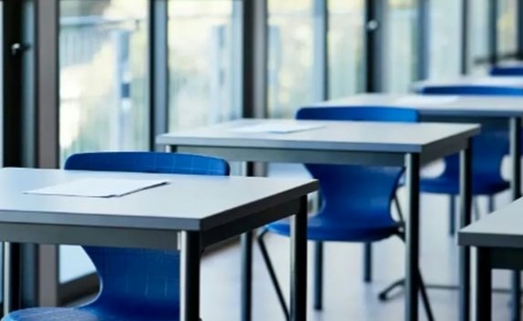 Aula con mesas y sillas azules preparadas para un curso de portugués.