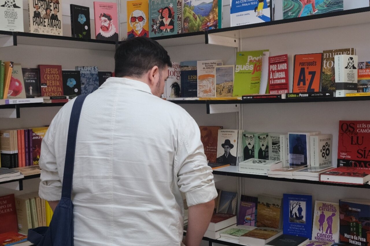 Visitante observando libros en el stand de literatura portuguesa.
