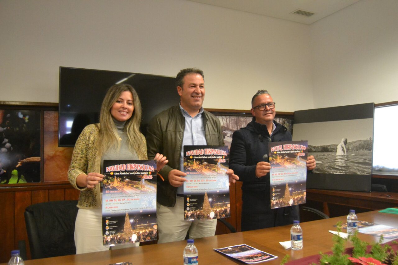 Tres personas sosteniendo carteles de Navidad Hispanolusa en una mesa