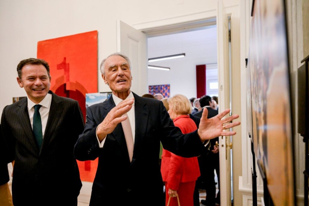 Luis Montenegro hablando en un evento con un fondo artístico