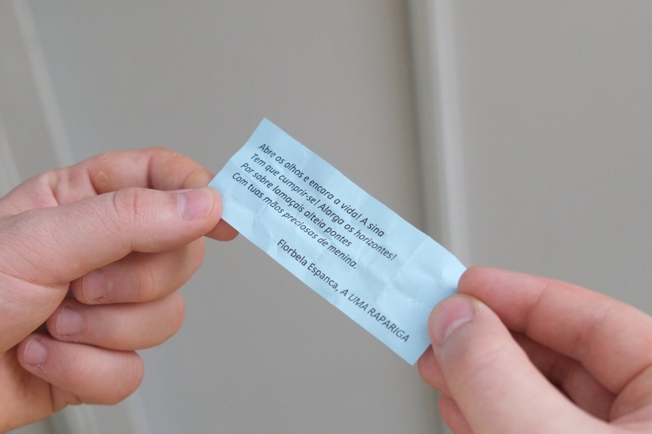 Nota con un poema de Florbela Espanca en una mano