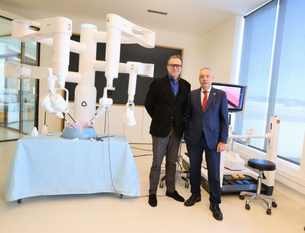 Dos hombres junto a un robot quirúrgico en DFactory Barcelona