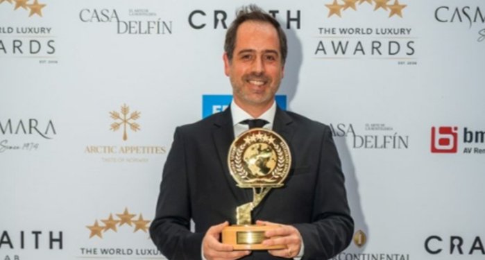 Hombre sosteniendo un premio en una gala de premios de lujo