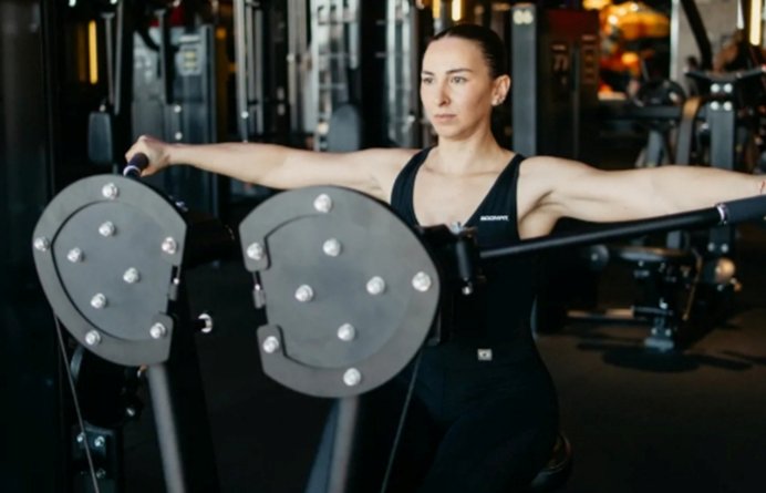 Mujer entrenando en un gimnasio con máquinas de musculación