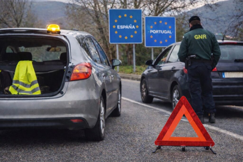 Vehículo detenido en la frontera entre España y Portugal con señal de advertencia.