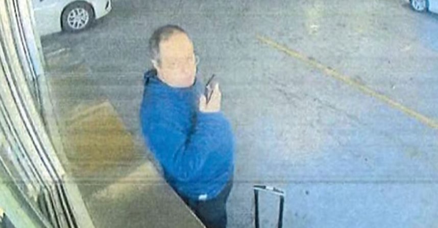 Sospechoso en un garaje con teléfono móvil en mano