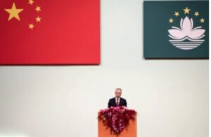 Líder de Macau hablando bajo banderas de China y Macau