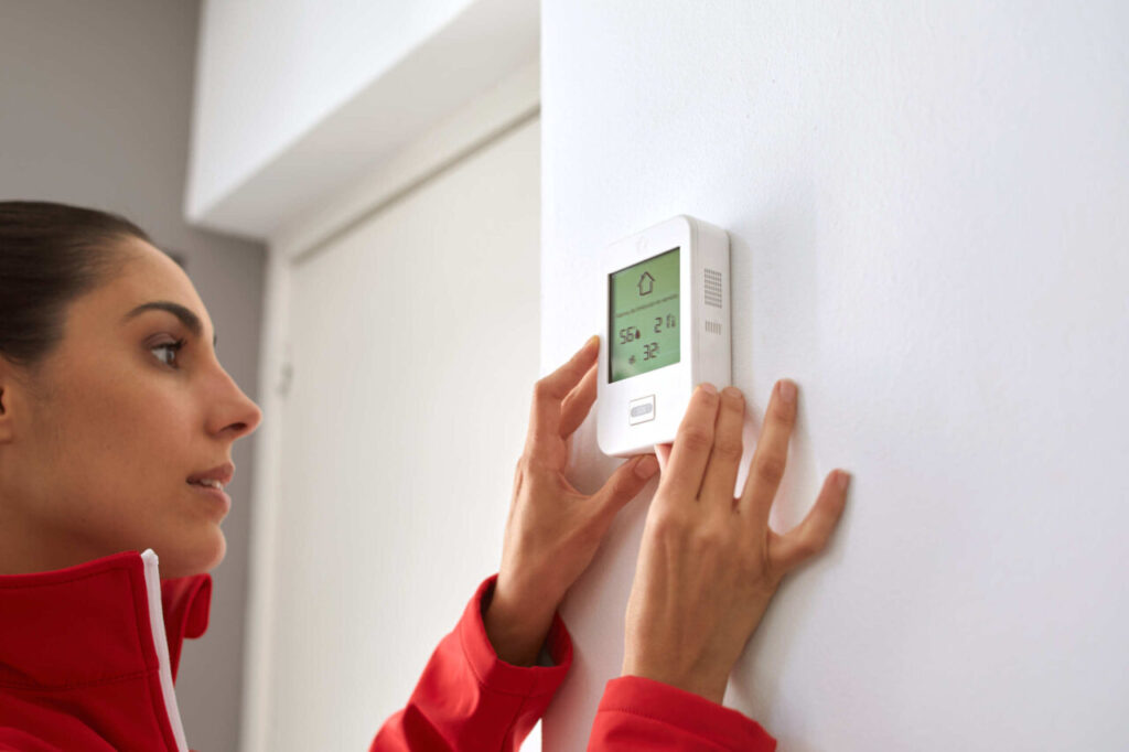 Técnico ajustando un dispositivo de seguridad en una pared.