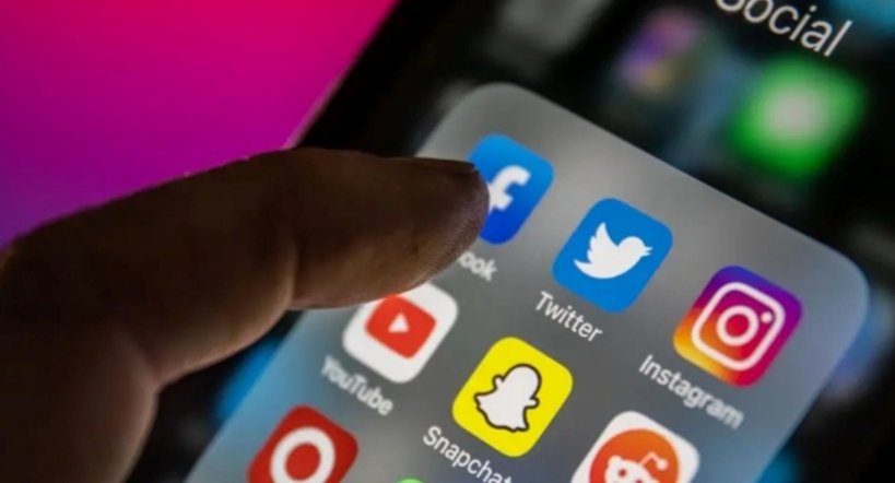 Mano tocando iconos de redes sociales en un smartphone