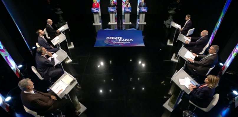 Candidatos a presidente debatiendo en un escenario de radio