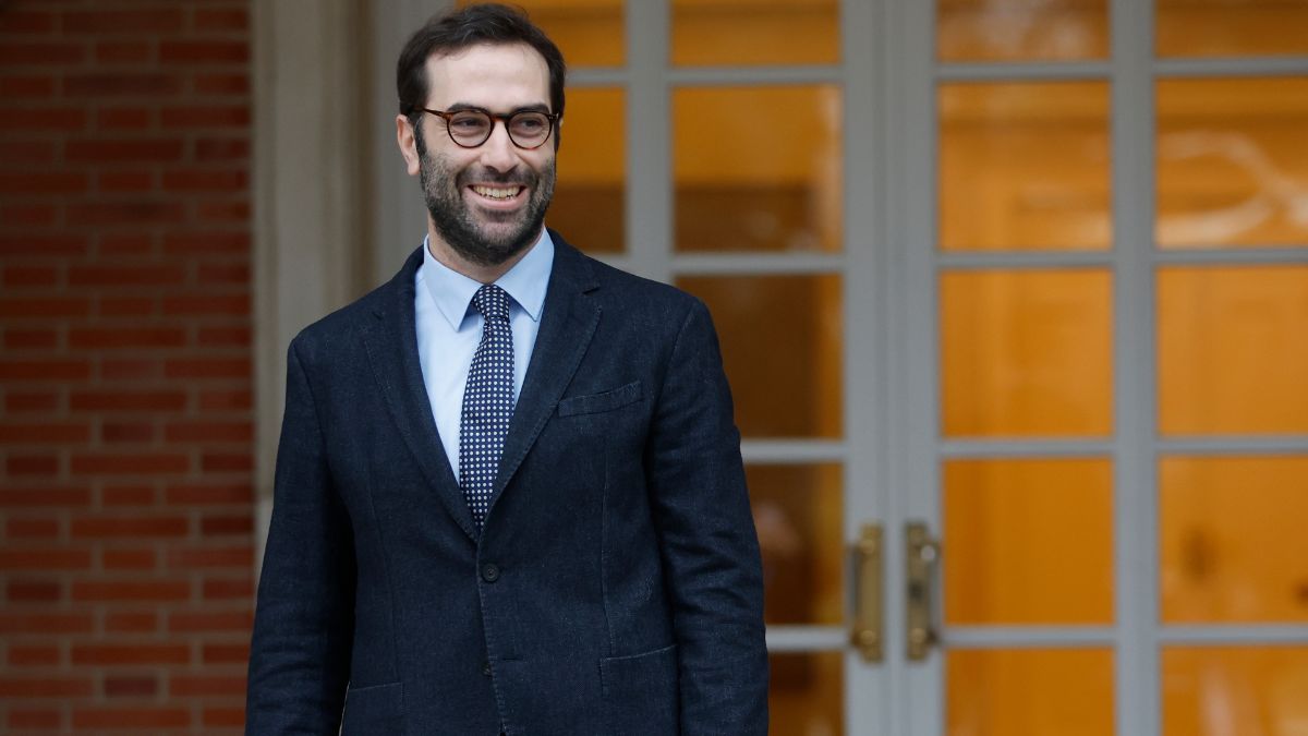 Ministro de Economía sonriendo frente a una puerta