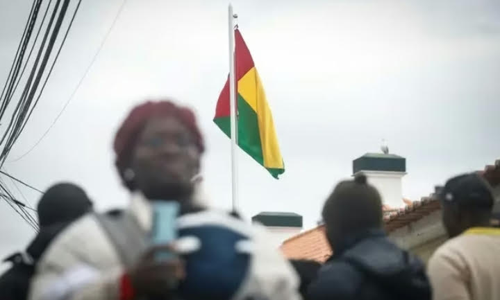 Bandera de Guinea-Bissau ondeando con personas en primer plano