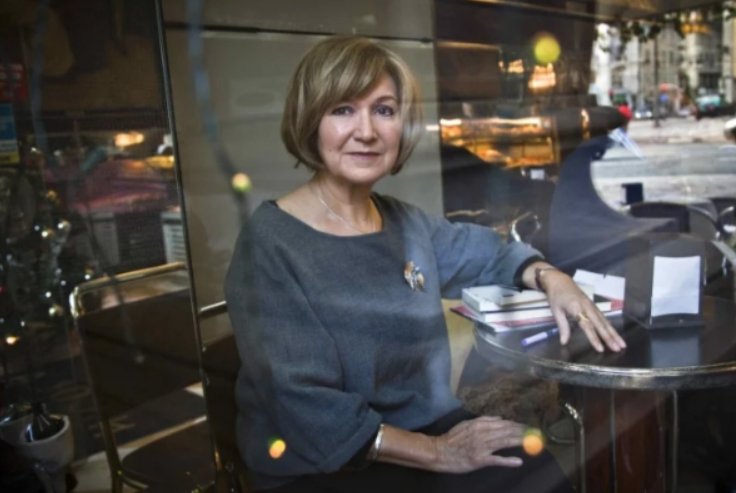 Lídia Jorge sentada en una mesa con libros y una taza