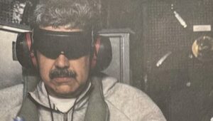 Nicolás Maduro con gafas oscuras y auriculares en un entorno oscuro