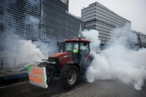 Tractor en protesta frente al Parlamento Europeo con humo y pancarta