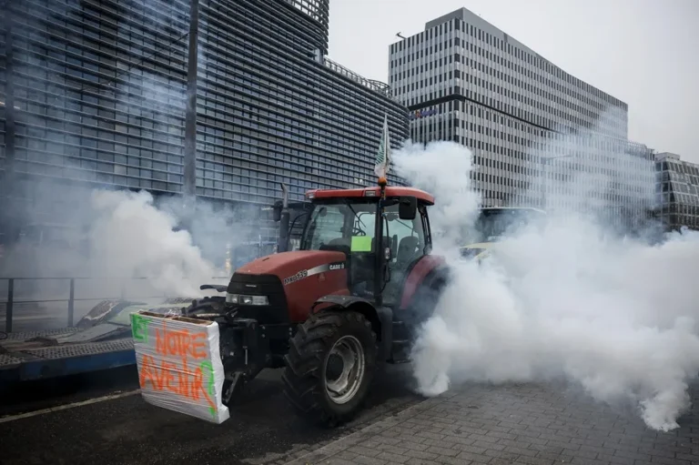 Tractor en protesta frente al Parlamento Europeo con humo y pancarta