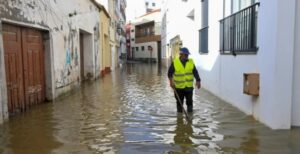 Hombre caminando por una calle inundada tras las tormentas en Portugal