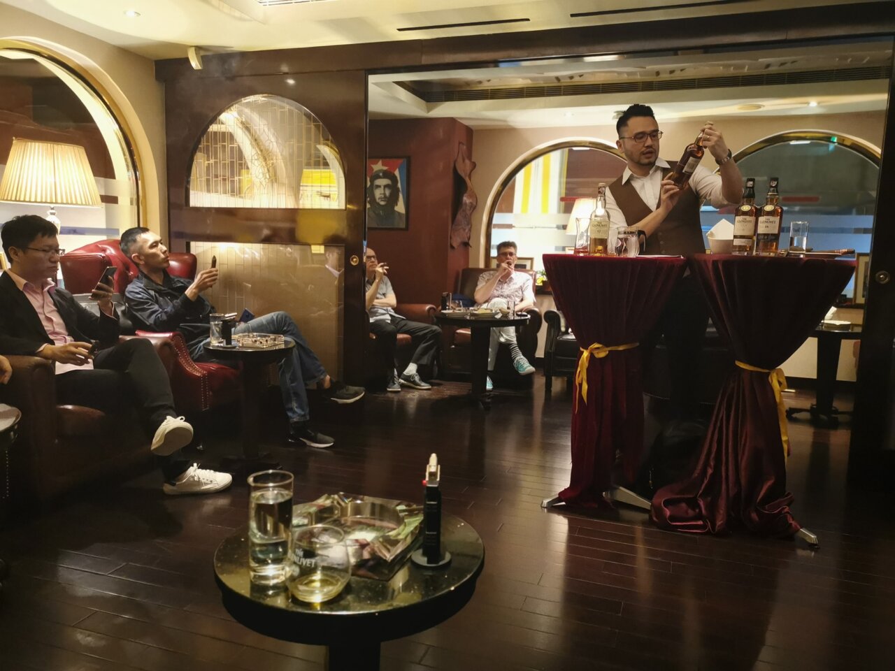 Un bartender sirviendo ron en un bar en Macao con clientes disfrutando.