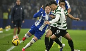 Jugadores del FC Porto y Sporting luchando por el balón en un partido de fútbol.