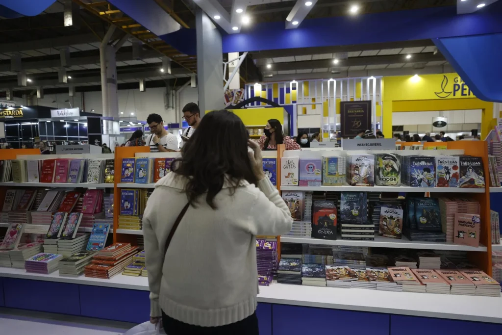 Mujer observando estantes de libros en una feria literaria