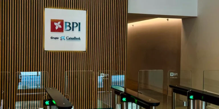 Interior de la oficina de BPI con logo de CaixaBank en la pared