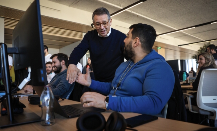 Interacción entre dos hombres en un entorno de oficina moderna.