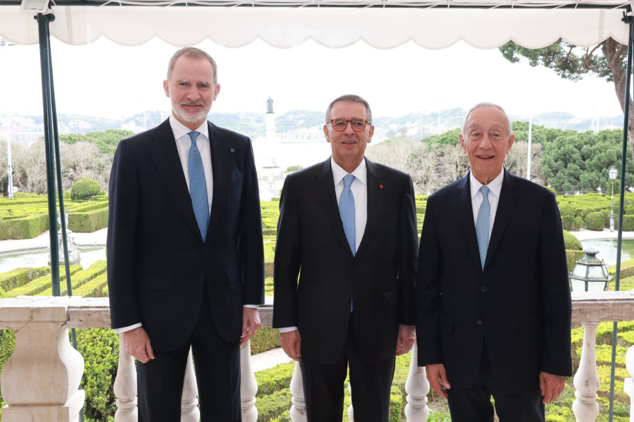 Tres hombres en traje en ceremonia de toma de posesión en jardines
