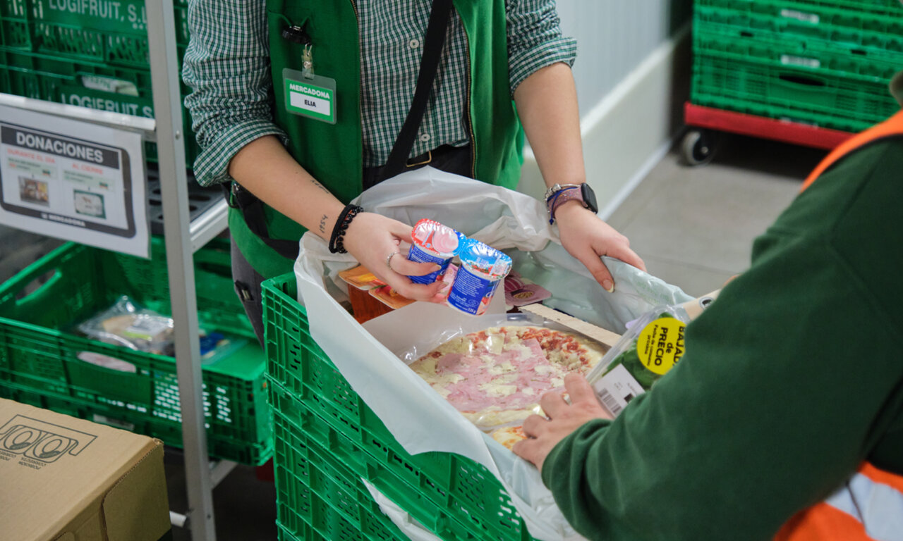 Personas entregando alimentos en una donación diaria en Mercadona.