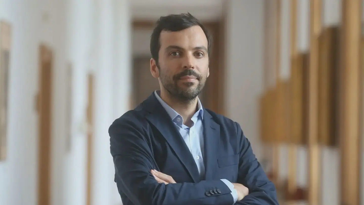Jorge Pinto posando en un entorno institucional con brazos cruzados