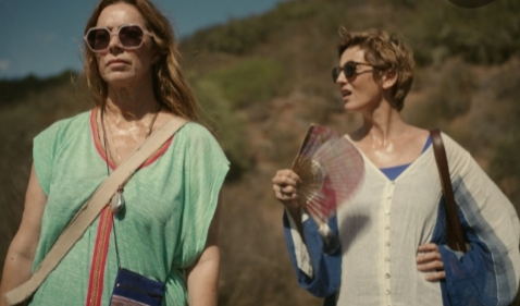 Dos mujeres caminando en un paisaje seco y caluroso