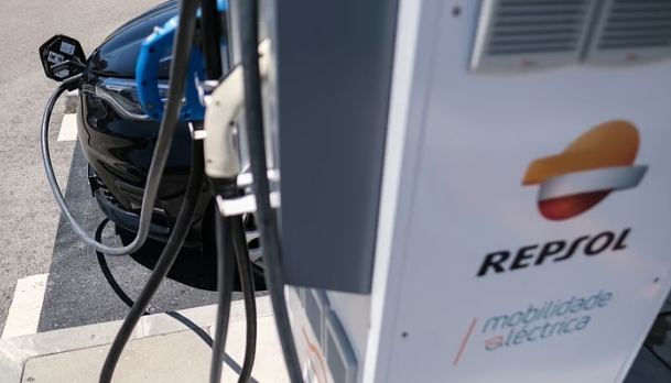 Estación de carga eléctrica de Repsol con un coche negro.