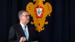António José Seguro hablando en un evento oficial con un fondo decorativo.