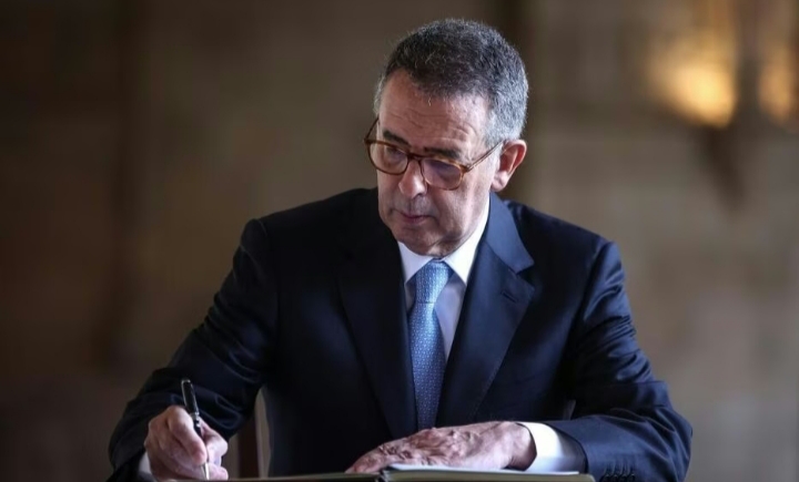 Hombre escribiendo en un libro en un entorno formal
