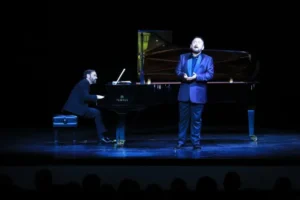 Un tenor mexicano canta mientras un pianista español lo acompaña en un concierto.