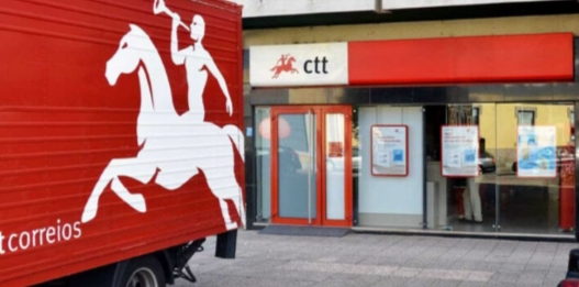 Camión de CTT frente a una oficina con logo en España