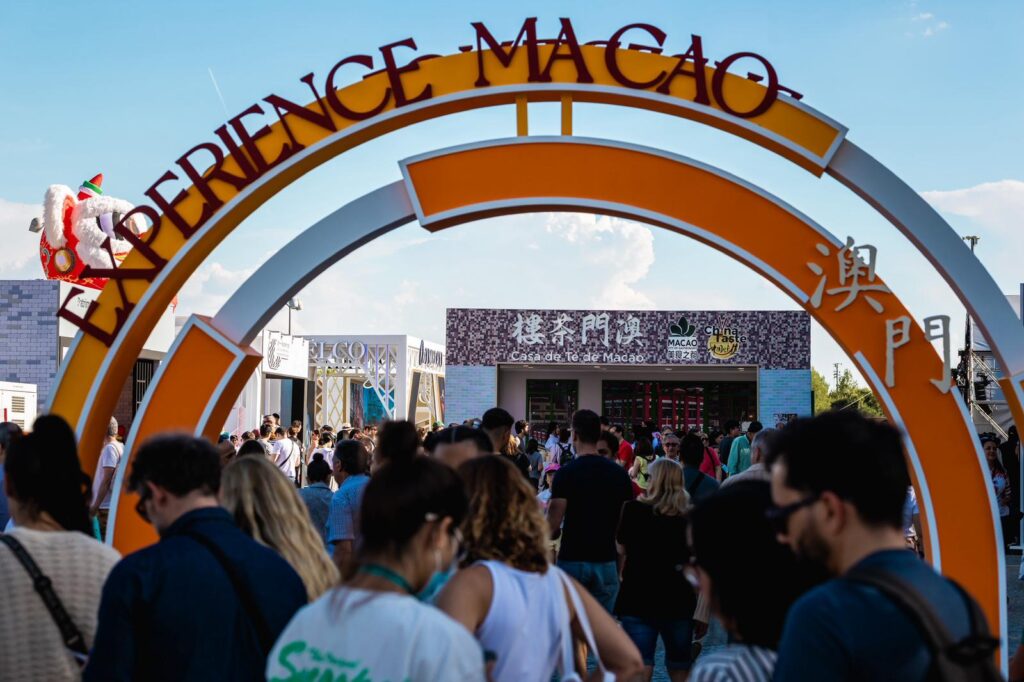 Arco de entrada al evento Experience Macao en Madrid con multitud de asistentes.