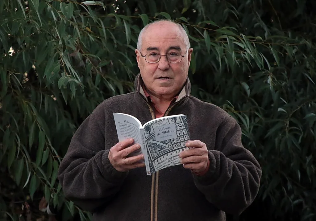 José Luis Puerto sosteniendo un libro en un entorno natural