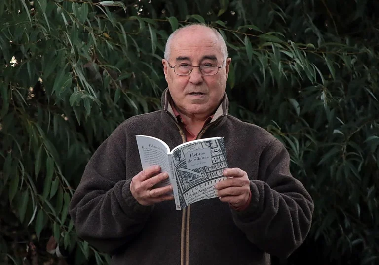 José Luis Puerto sosteniendo un libro en un entorno natural