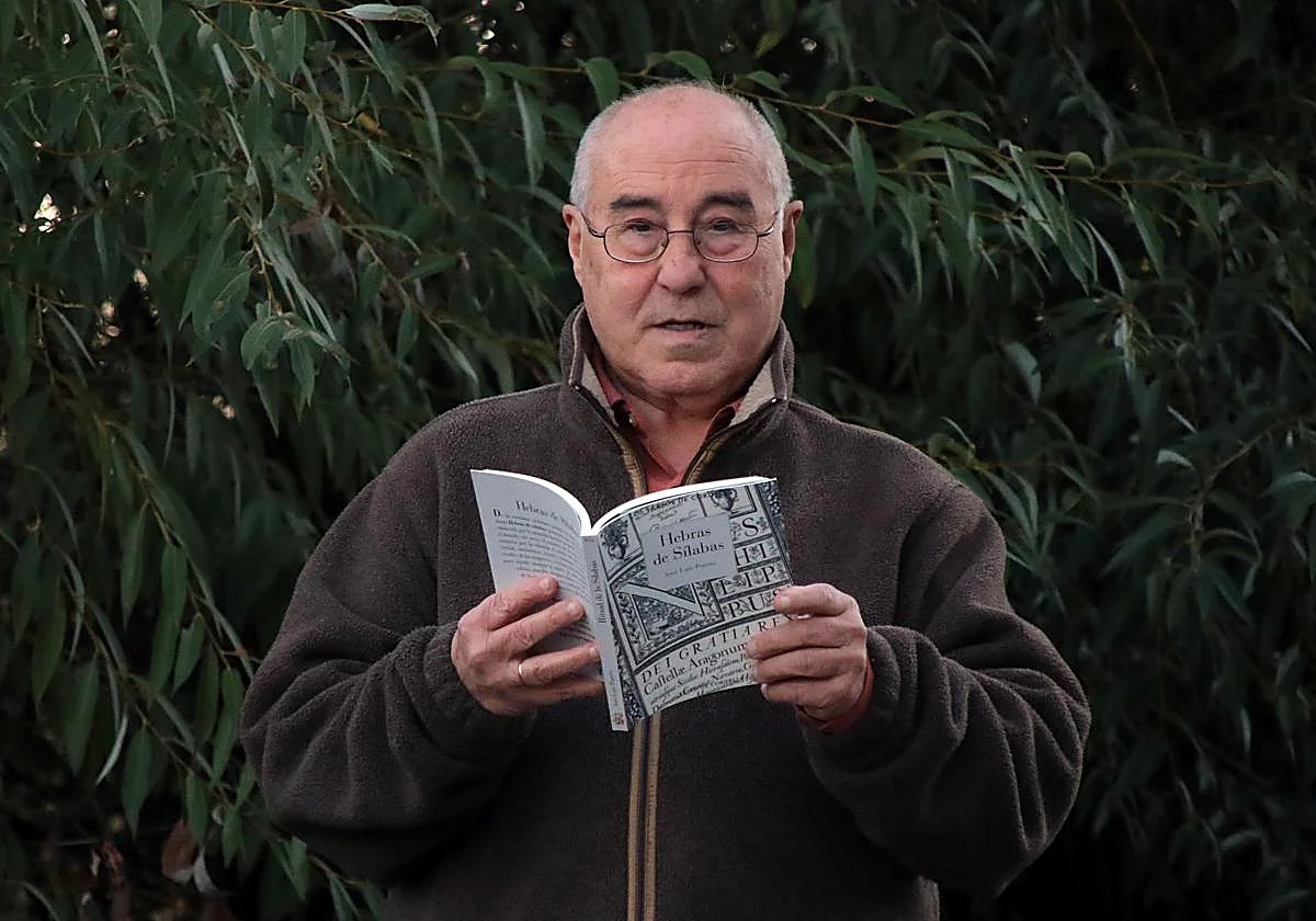 José Luis Puerto sosteniendo un libro en un entorno natural