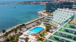 Vista de un hotel moderno junto al mar con piscina
