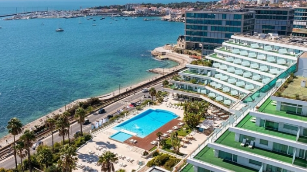 Vista de un hotel moderno junto al mar con piscina