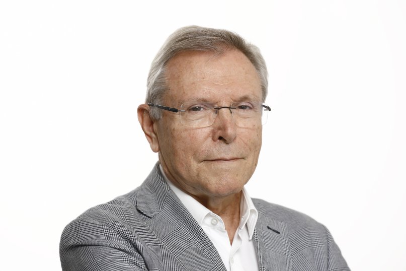 Retrato de un hombre mayor con gafas y chaqueta gris