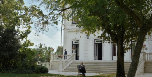 Escena del filme sobre Salazar con un hombre sentado en un jardín.
