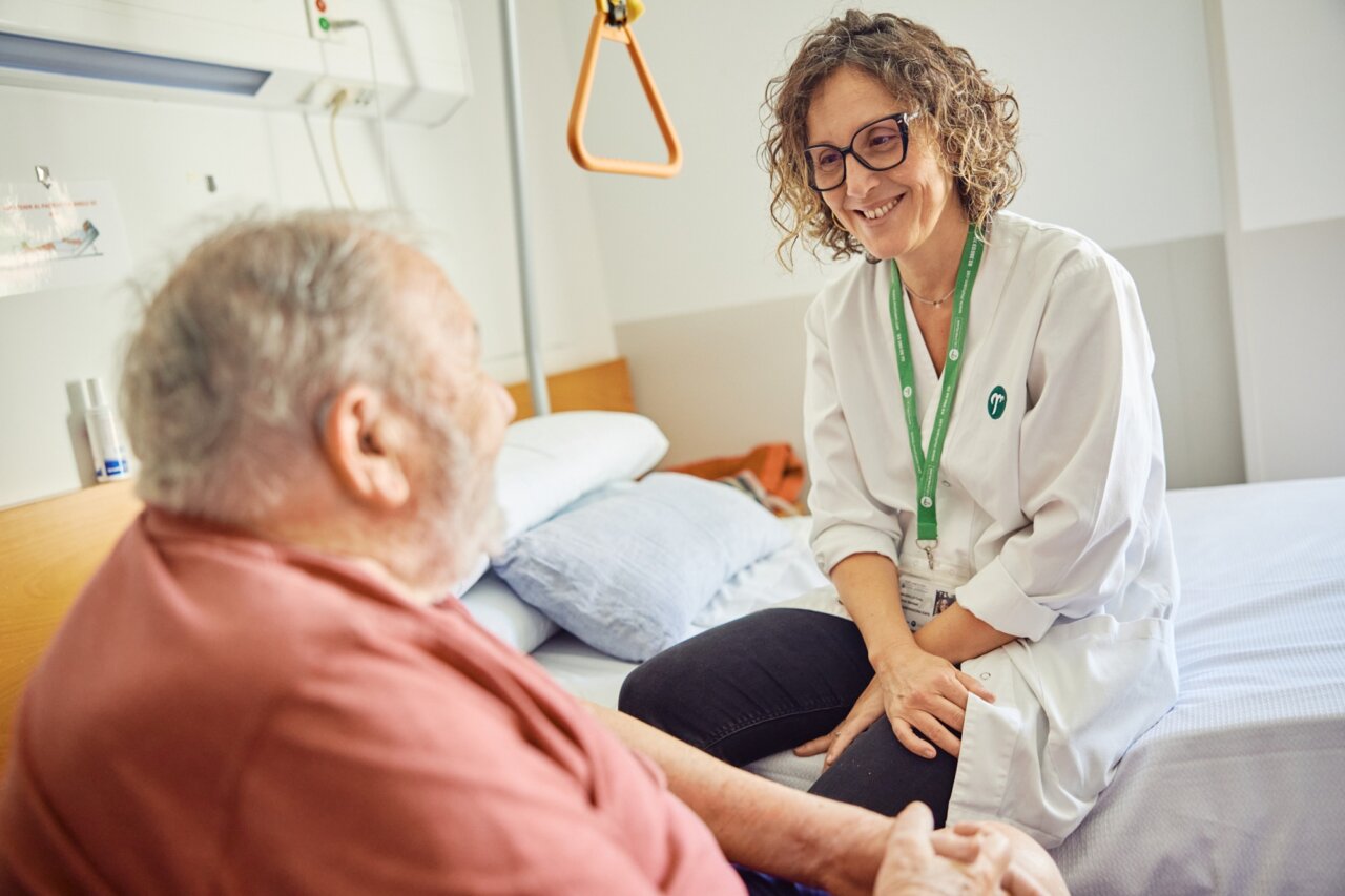 Profesional de salud conversando con un paciente en un entorno hospitalario